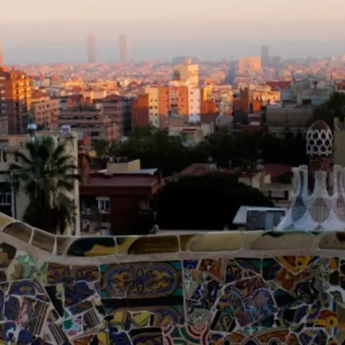 A look at a multi-colored wall with class and tile with a city in the background