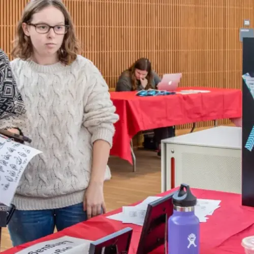 Three people at a table for an activities fair