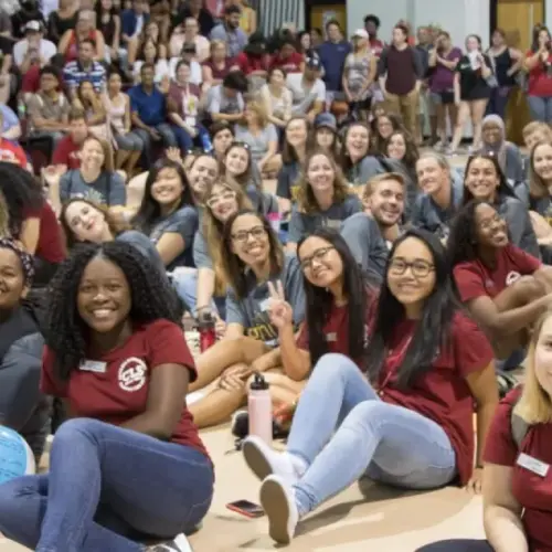 A very large group of students sitting in the gymnasium