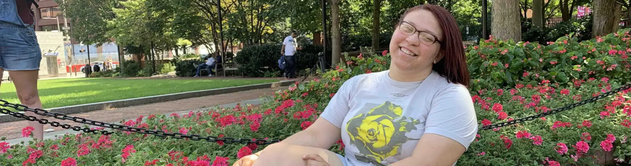 A student lounges near a garden