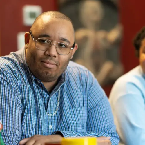 Christopher Allen Varlack and a student listen to a conversation.