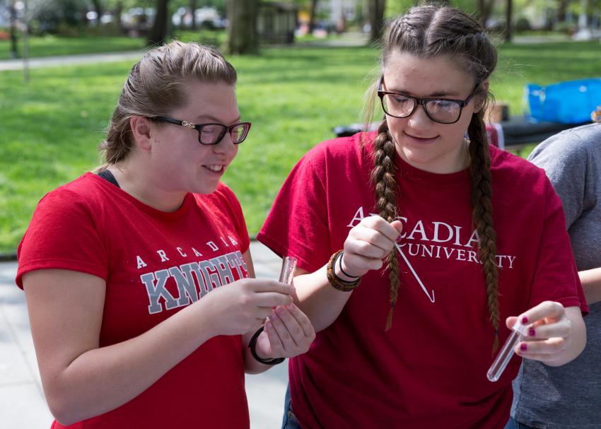 Two students holding small test tubes.