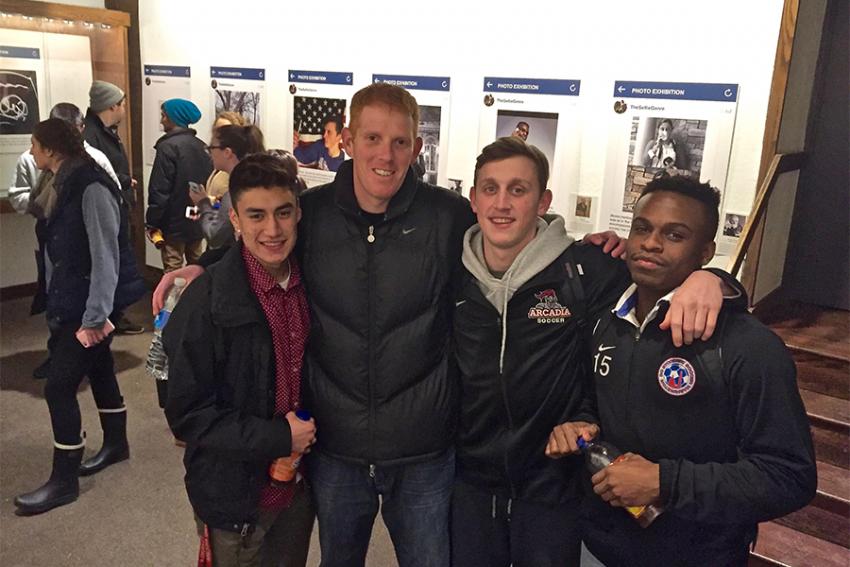 Photo of soccer players and their coach at an art exhibit.