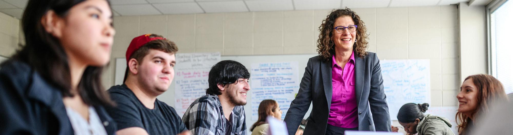 Professor talking to students at table