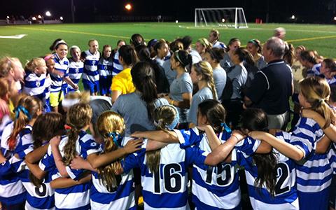 A women's soccer team huddle