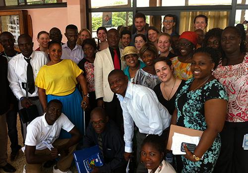 A group of people, half Black and half white, smiles at the camera