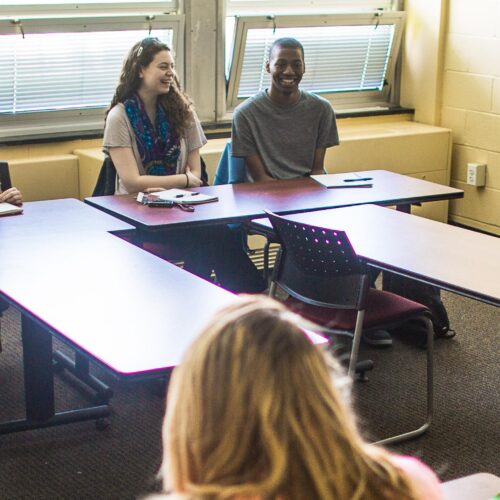 Student standing at front of classroom.