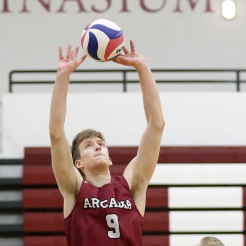 A student playing volleyball in the gymnasium