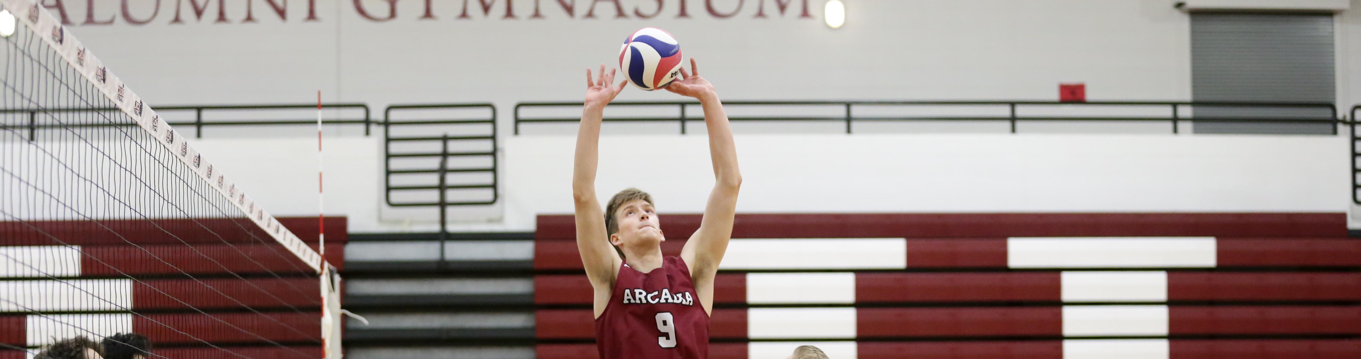 A student playing volleyball in the gymnasium