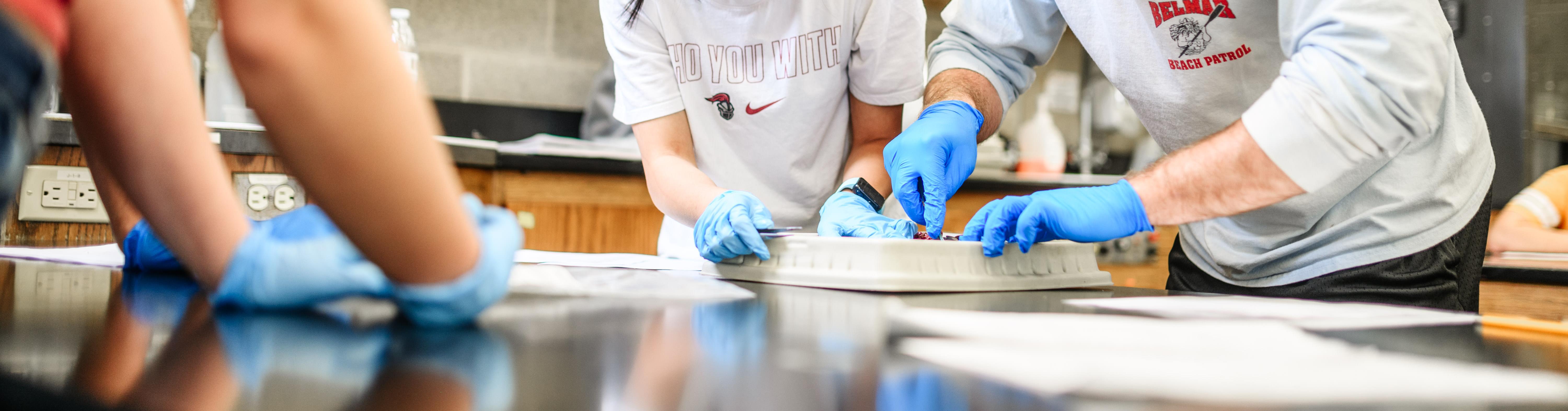 Two students and a teacher working together in a lab.