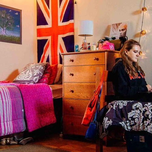 Two students in their dorm with country flags on the walls