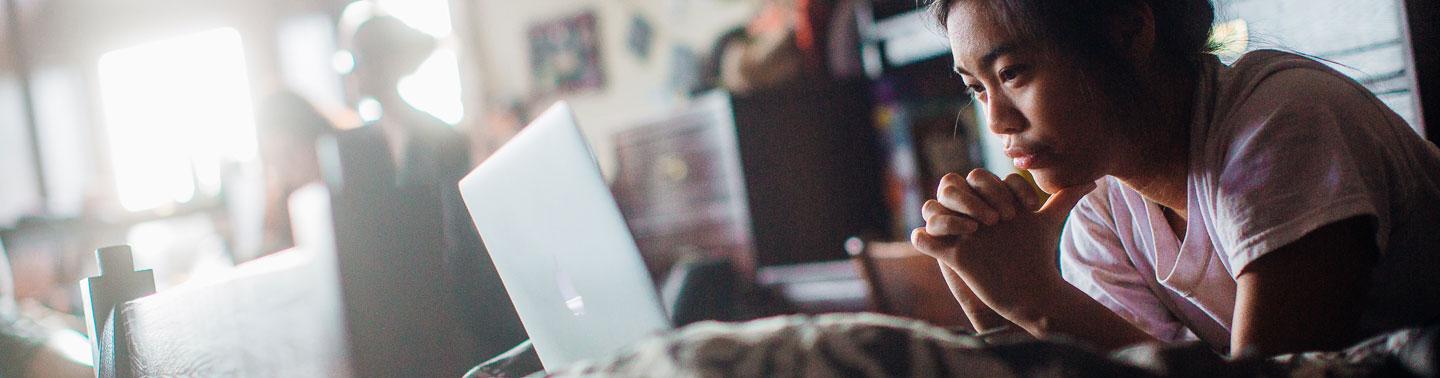 A student watching a movie on her laptop