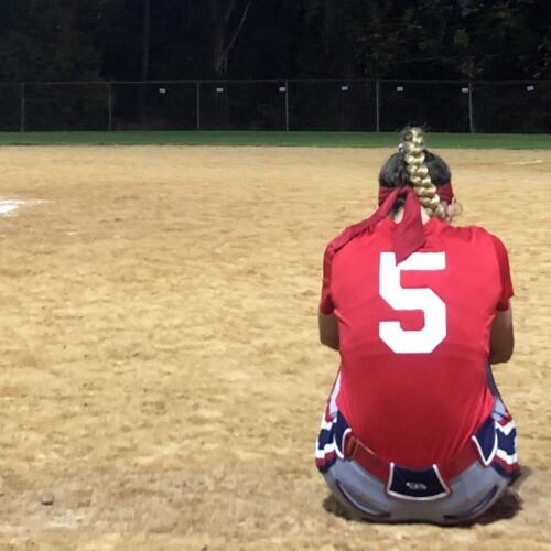 Two people sitting on baseball field