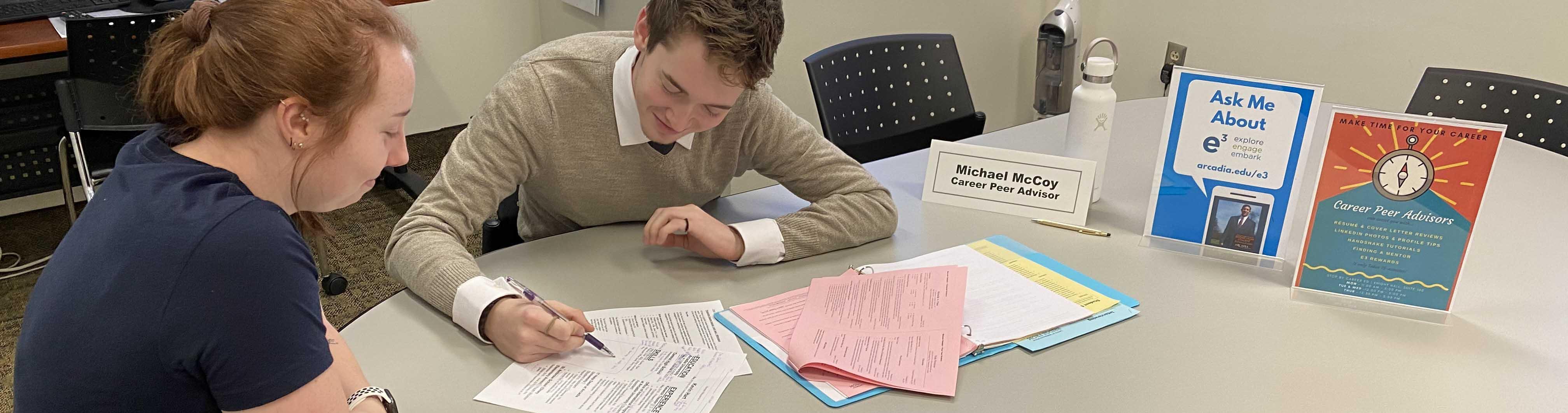 A career peer advisor works with a fellow student