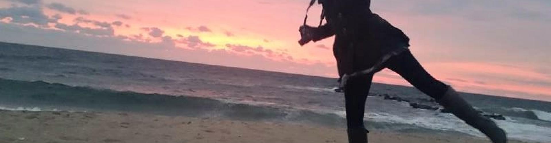 Student getting ready to take a picture at the beach.