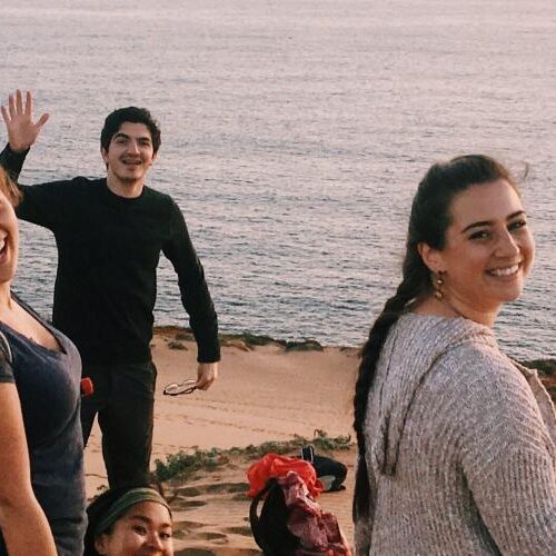 People smiling at the camera while on a beach side in Chile