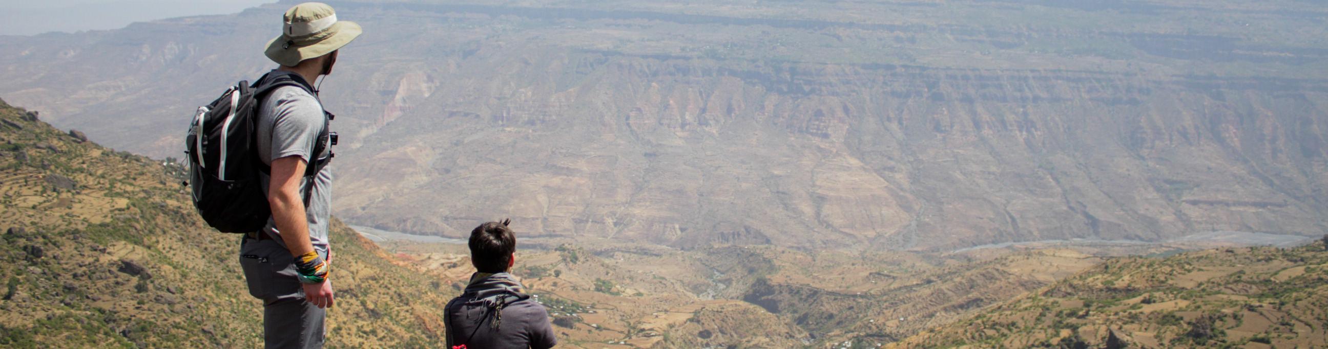 Two people looking over a canyon