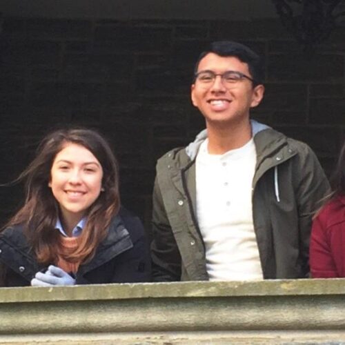 Photo of smiling students standing on the covered patio of Grey Towers Castle.