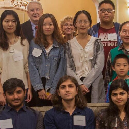 International Students and others sitting on and standing behind a couch