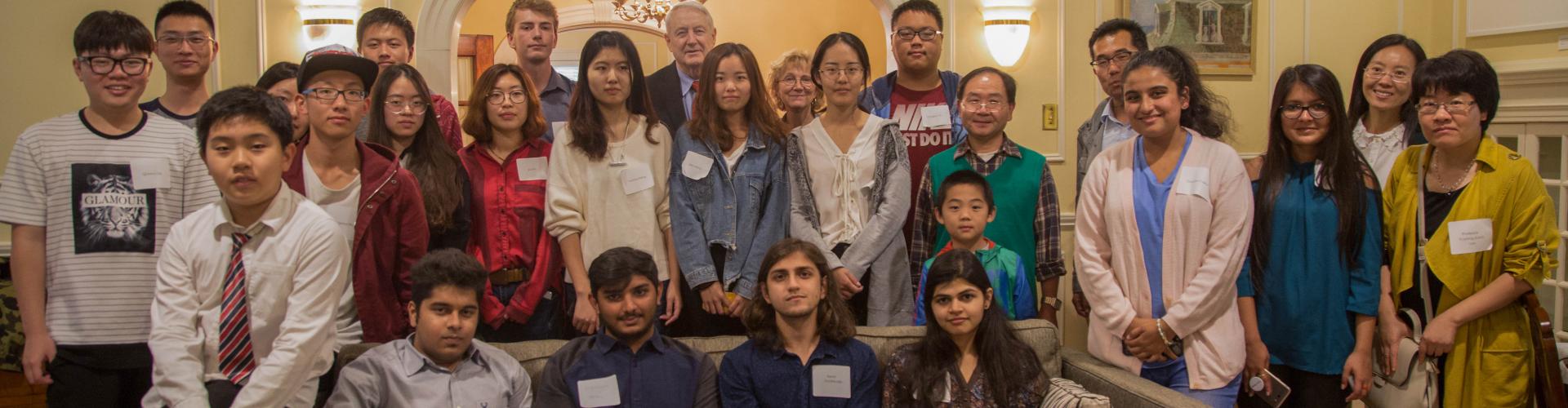 International Students and others sitting on and standing behind a couch