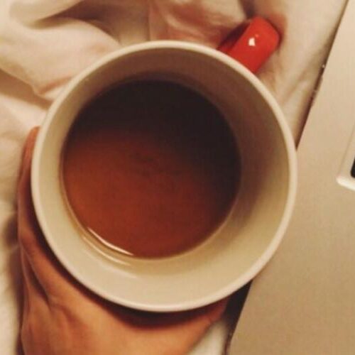 Aerial view of a cup of coffee and a laptop keyboard