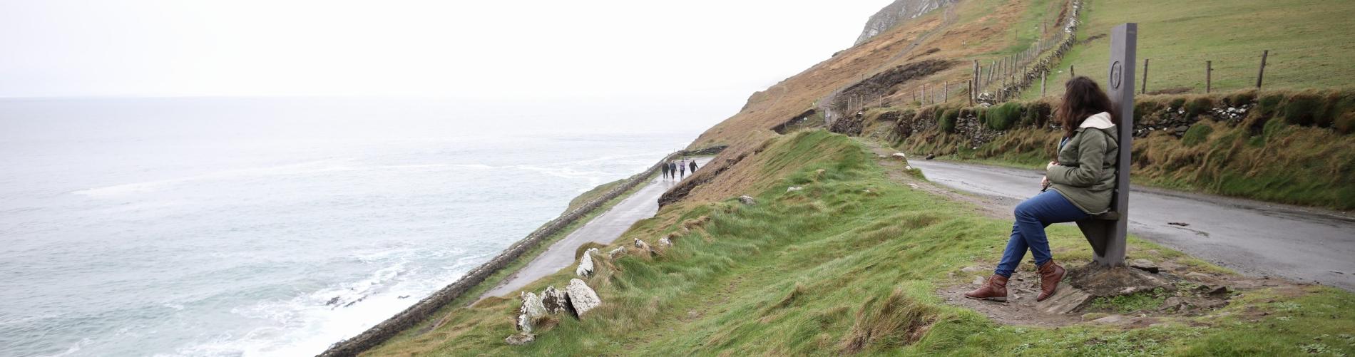 wide cliff shot of student overlooking the ocean