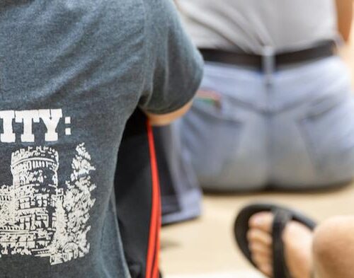 A photo of the back of a shirt that reads Building Community: It's What We Do.