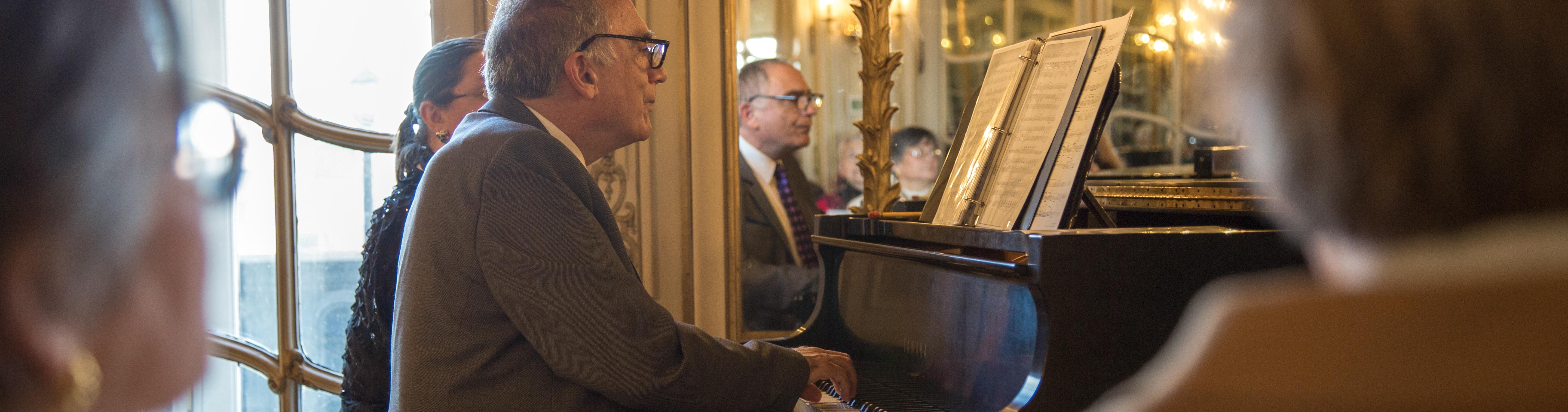 action shot off Samuel Heifetz playing the piano in the Mirror room