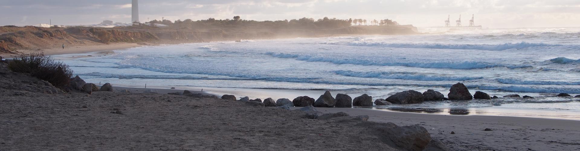 wide shot of the foggy beach - the waves are rippling before it hits shore