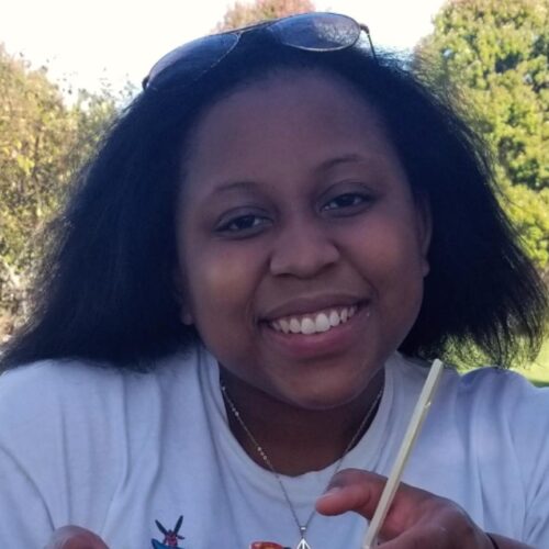 Daijah Patton with a basketball courtyard and forest in the background