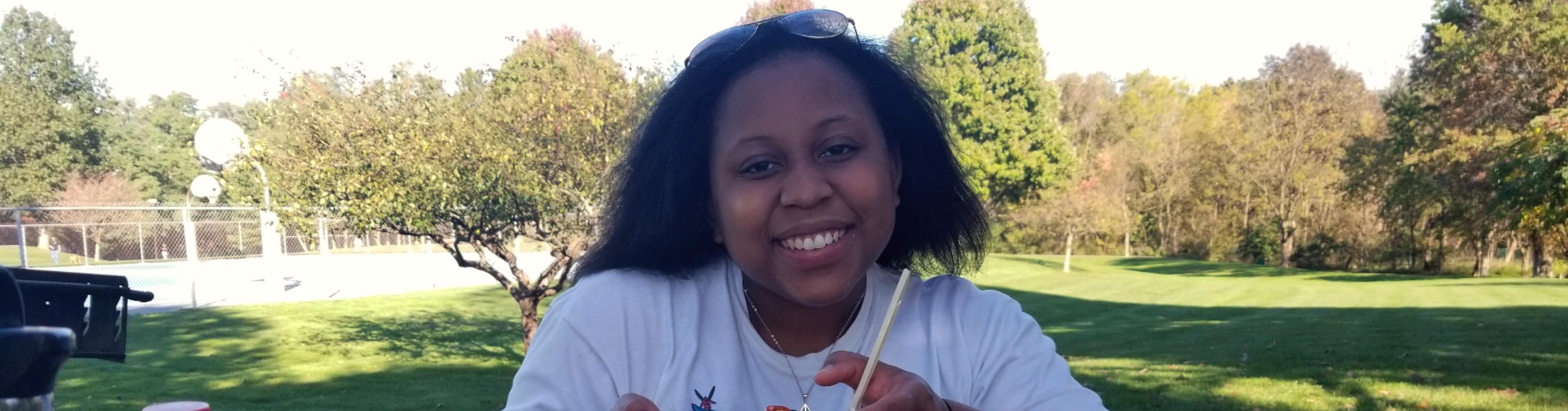 Daijah Patton with a basketball courtyard and forest in the background