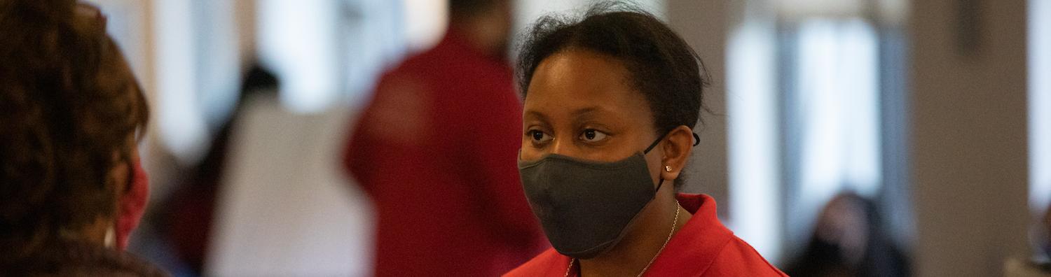 A faculty member wearing a mask at an open house event.