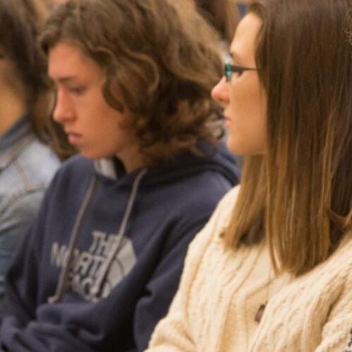 Students sitting and taking notes during a presentation.