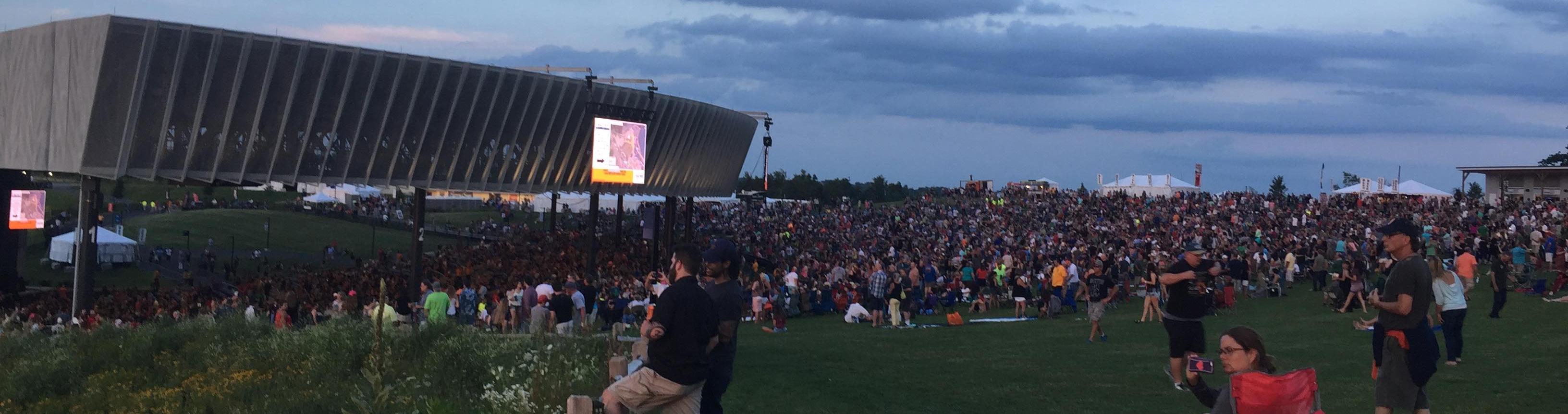 A large crowd at an outdoor concert in the evening