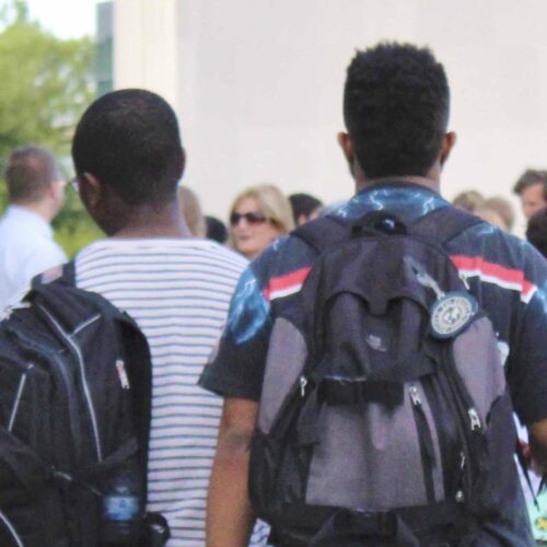 Students walking around campus, wearing backpacks.