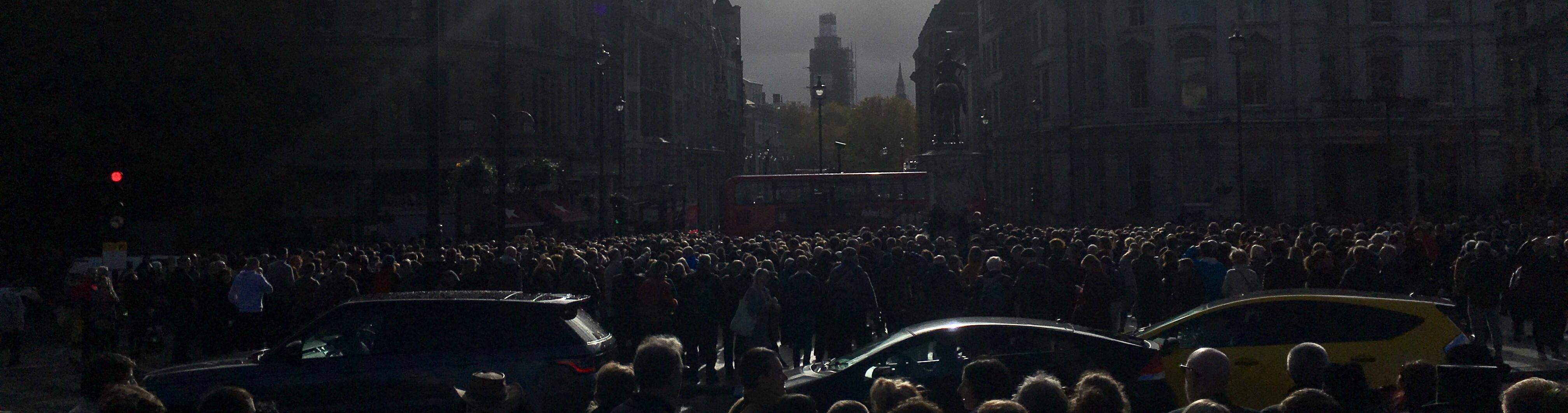 A darken image of a crowd of people in a busy city