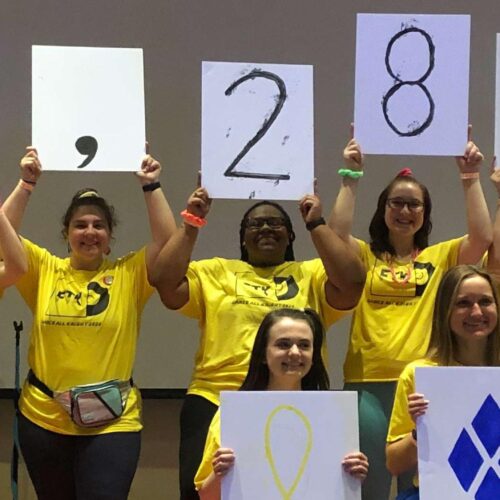 students holding up signs that show how much they raised - $8,286.60~