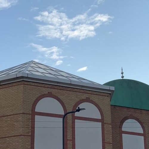 Photo of the top of a building with a green dome.