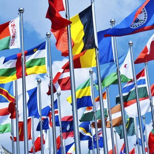 Collective display of international flags on flagpoles.