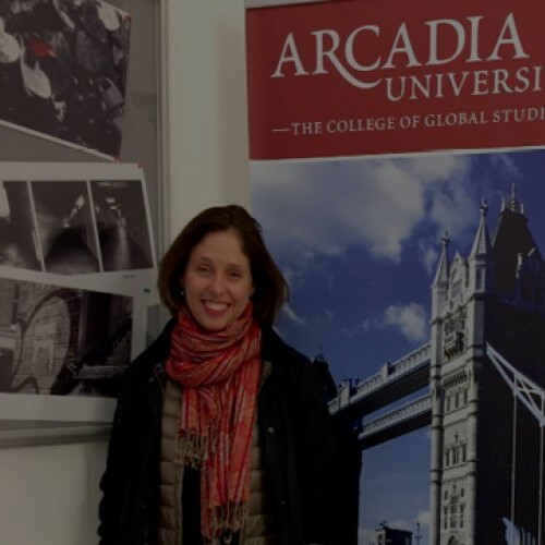 Louise Burns in front of a banner for Arcadia's College of Global Studies.