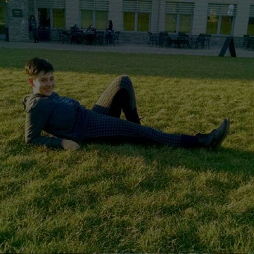 A dark collage of portraits with a person laying on Haber Green in center