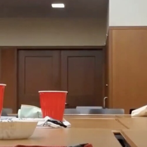 Students sitting at a desk with red plastic cups