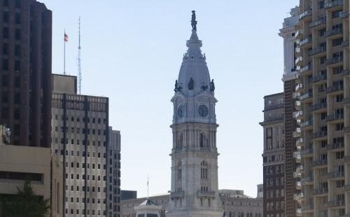 A panoramic view of Philadelphia with a large clock tower at the center.