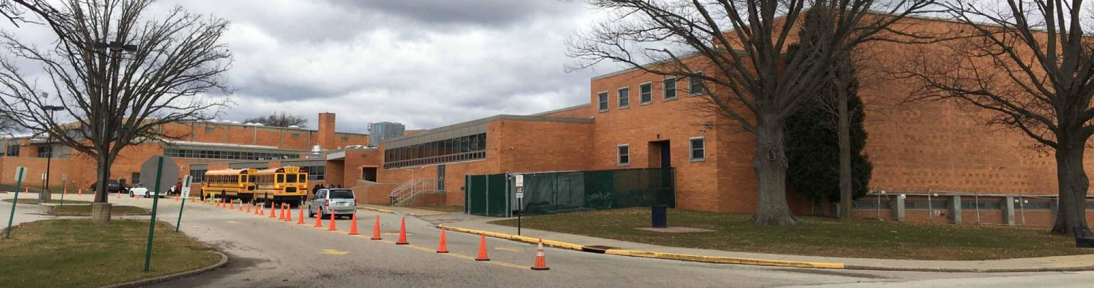 exterior shot of a high school with buses outside