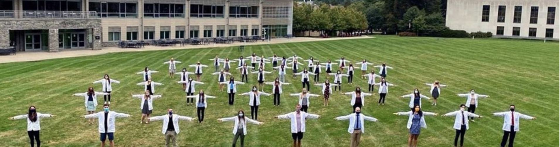 Physician assistant students standing six feet apart from each other while wearing masks.