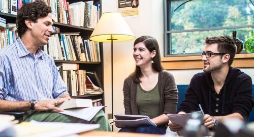 A photo of three people having a conversation.