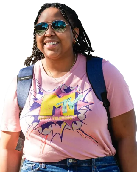 A student wearing a backpack, smiling at the camera.