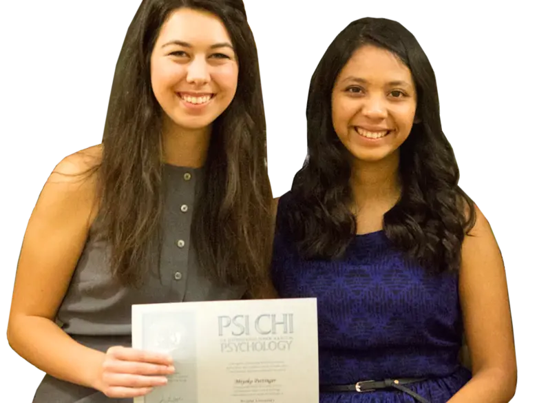 Two female students hold up a PSI CHI certificate