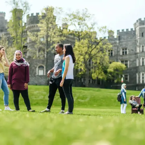 Students gather on Haber Green with the castle in the background.