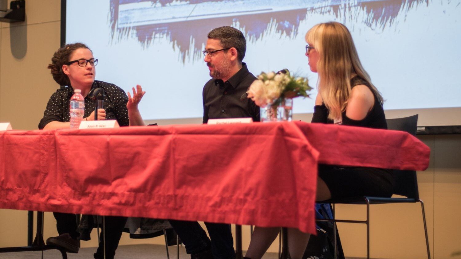 three people sitting at a table during a gallery talk